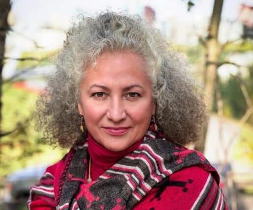 A headshot of a person standing outside.