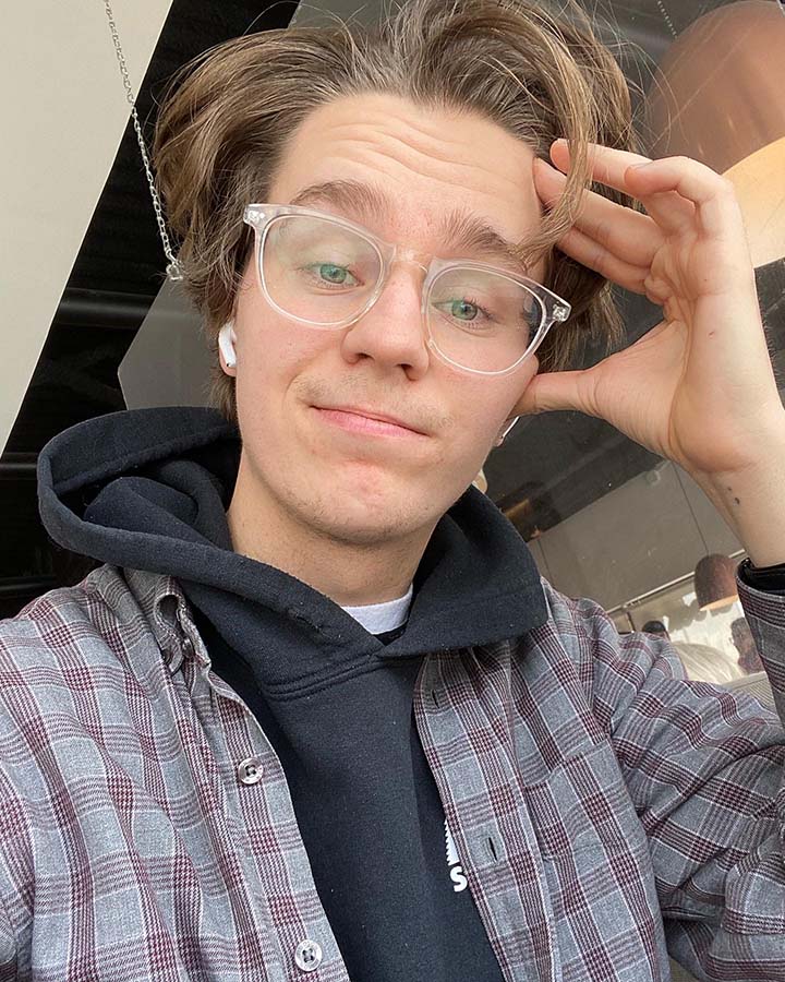 A photo of Gavin wearing a checkered sweater.