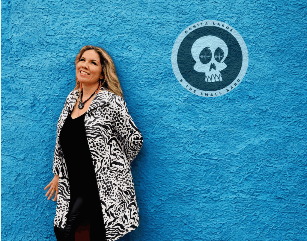 Artist smiles at camera in front of blue background