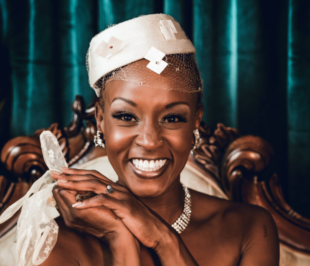 A smiling woman sits on a sofa.