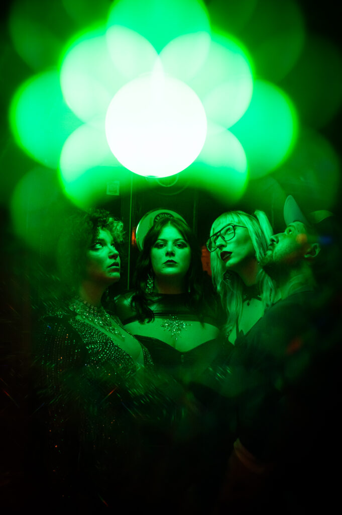 Four artists stare up at a green light.