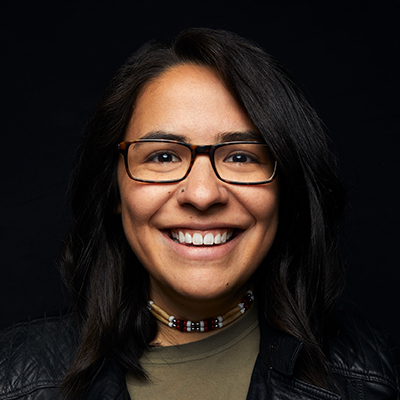 A headshot of Jacquelyn Cardinal wearing rectangular glasses and a green shirt.