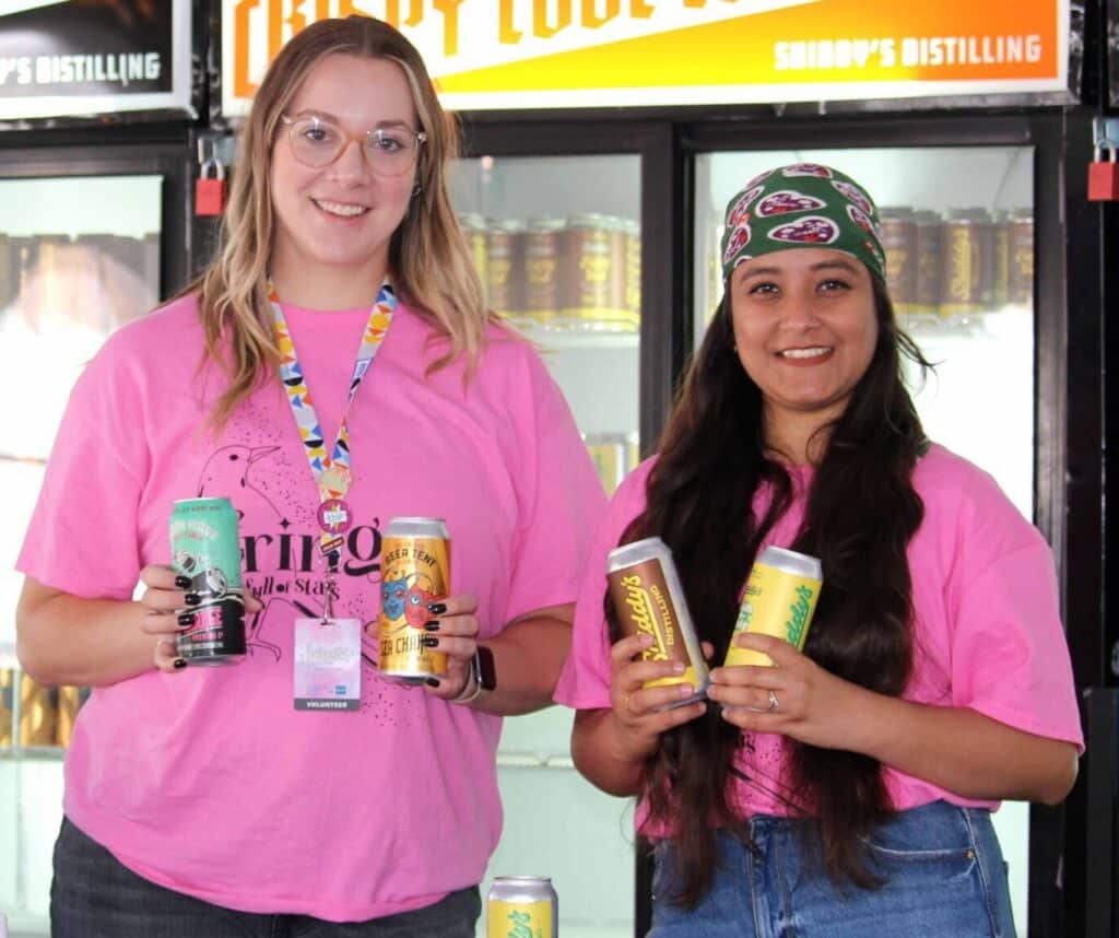 Two Beer Tent Volunteers pose with Sea Change products