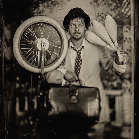 Black and White image of Corey posing with a bicycle tire.